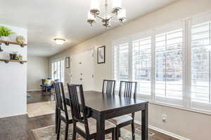 Dining area featuring dark hardwood / wood-style flooring and a notable chandelier