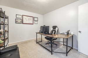 Carpeted office space featuring a textured ceiling