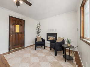 Living area featuring ornamental molding, light hardwood / wood-style floors, and ceiling fan