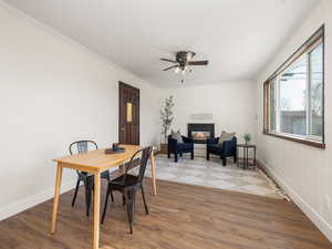 Dining room with wood-type flooring, ornamental molding, and ceiling fan