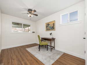 Office space with dark wood-type flooring and ceiling fan