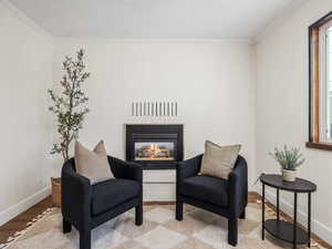 Sitting room featuring crown molding, brick wall, and light hardwood / wood-style floors