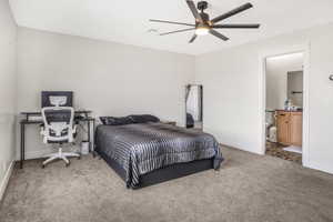 Bedroom featuring ensuite bath, carpet floors, and ceiling fan