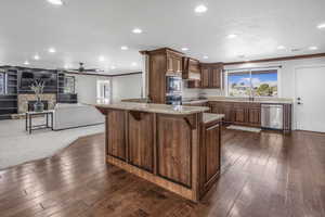 Kitchen featuring a breakfast bar, built in microwave, dishwasher, dark hardwood / wood-style flooring, and ornamental molding