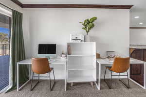 Carpeted home office with crown molding