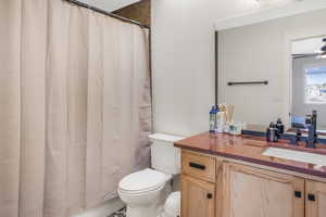 Bathroom with vanity, curtained shower, and toilet