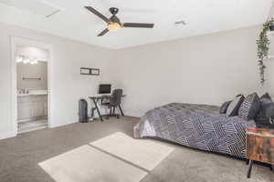 Carpeted bedroom featuring ceiling fan, connected bathroom, and sink