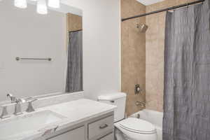 Full bathroom featuring vanity, shower / tub combo, and toilet