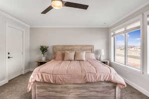 Bedroom with carpet floors, ornamental molding, and ceiling fan