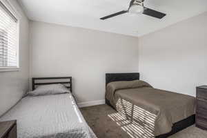 Carpeted bedroom featuring ceiling fan