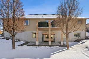 Snow covered rear of property featuring central AC unit