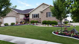 Summer/Spring View of front of house with a garage and a front lawn