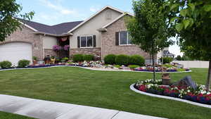 Summer/Spring View of front of house with a garage and a front lawn