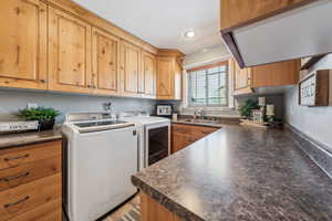 Laundry room featuring cabinets, sink, and washing machine and dryer