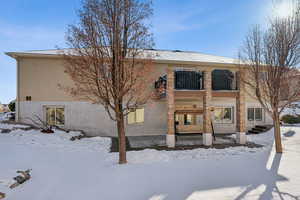 Snow covered rear of property featuring central AC