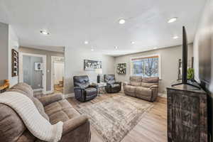 Living room with light hardwood / wood-style floors and a textured ceiling