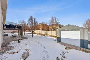 View of snow covered accessory garage for storage and toys