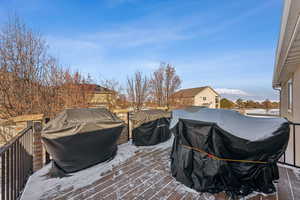 Snow covered deck featuring grilling area Deck off of kitchen
