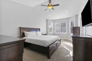 Carpeted bedroom with lofted ceiling and ceiling fan