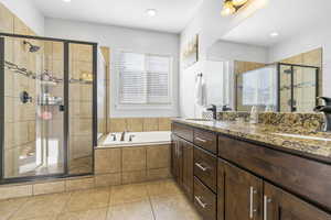 Bathroom featuring vanity, independent shower and bath, and tile patterned flooring