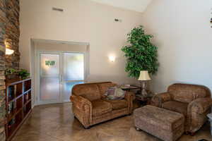 Sitting room featuring tile patterned flooring and high vaulted ceiling