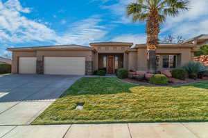 View of front facade featuring a garage and a front lawn