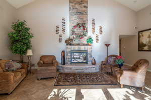 Living room with a fireplace and high vaulted ceiling