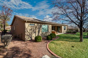 Rear view of house with a patio area and a lawn