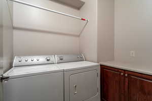 Washroom with cabinets and washing machine and clothes dryer