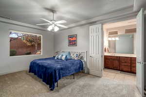 Bedroom featuring sink, ensuite bath, ceiling fan, a textured ceiling, and light tile patterned flooring