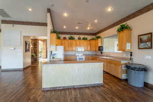 Kitchen featuring sink, white appliances, dark hardwood / wood-style floors, a kitchen island, and kitchen peninsula