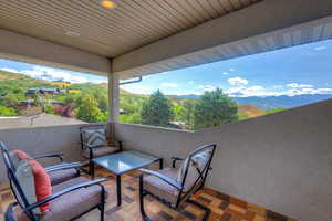 View of patio featuring a balcony and a mountain view