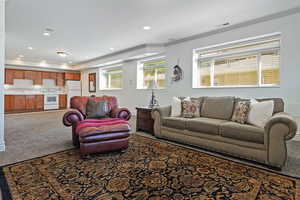 Living room featuring ornamental molding and carpet flooring