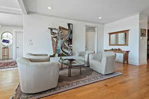 Living room featuring crown molding and light hardwood / wood-style flooring