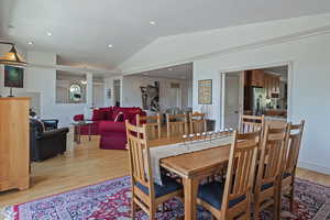 Dining area featuring lofted ceiling and light wood-type flooring