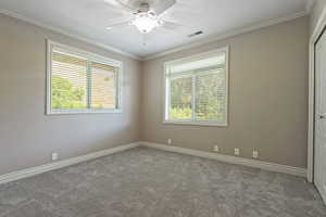 Unfurnished room with ornamental molding, light colored carpet, and ceiling fan