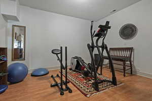 Workout area with hardwood / wood-style floors