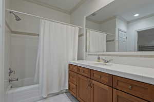 Bathroom featuring ornamental molding, shower / bath combo, vanity, and backsplash