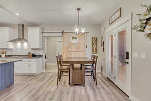 Dining area featuring a barn door and light wood-style flooring