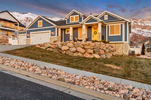 Craftsman-style home with 3 car garage, a mountain view, and terraced yard