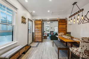 Dining space with hardwood / wood-style flooring and a barn door