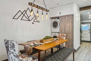 Dining area featuring stacked washer and clothes dryer, a barn door, and light hardwood / wood-style flooring