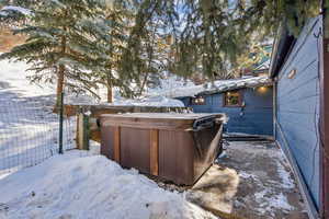 Snowy yard featuring a hot tub