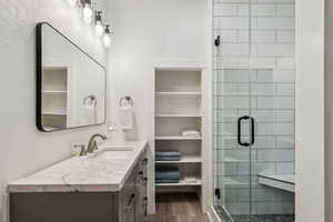 Bathroom featuring vanity, an enclosed shower, and hardwood / wood-style floors