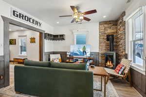 Living room with ceiling fan and light hardwood / wood-style floors