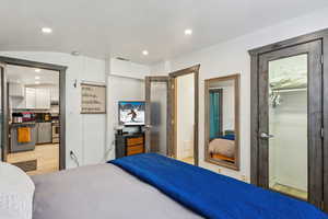 Bedroom featuring a walk in closet, ensuite bath, a closet, and light wood-type flooring