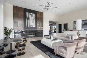 Living room featuring a notable chandelier, a fireplace, and a high ceiling