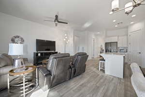 Living room featuring light wood-type flooring, sink, and ceiling fan