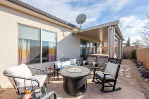 View of patio / terrace with a hot tub and a fire pit