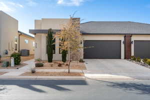 View of front facade with a garage and central AC